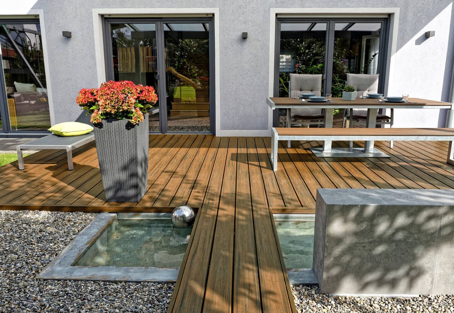 Braune WPC Terrasse mit Wasserspiel.