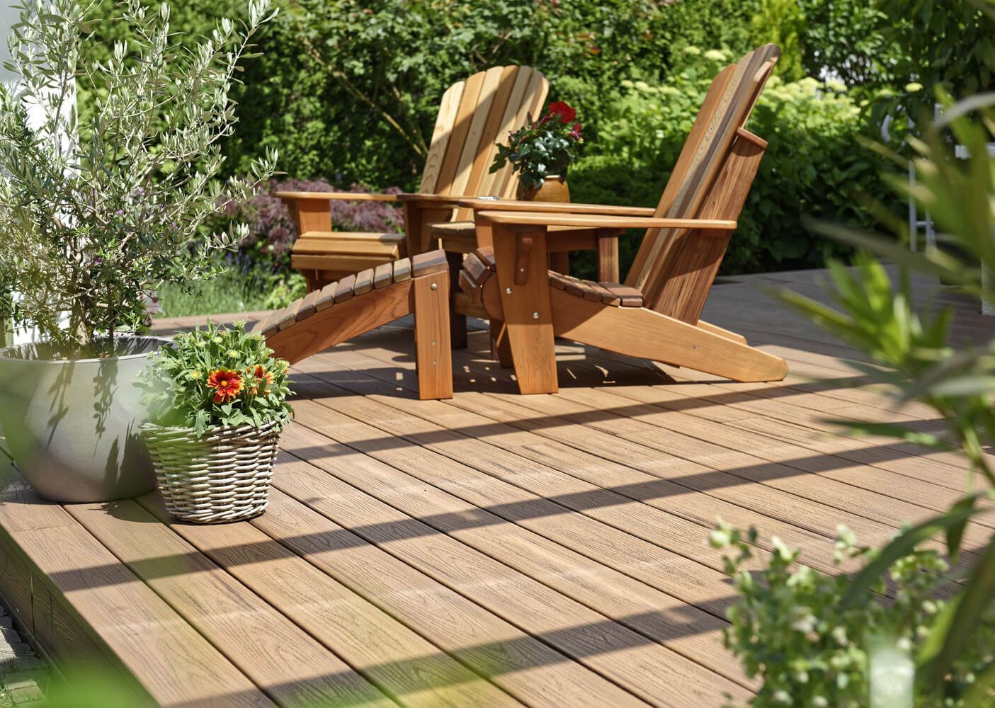 Urige unüberdachte Terrasse im Garten mit Holzstühlen und Pflanzen.